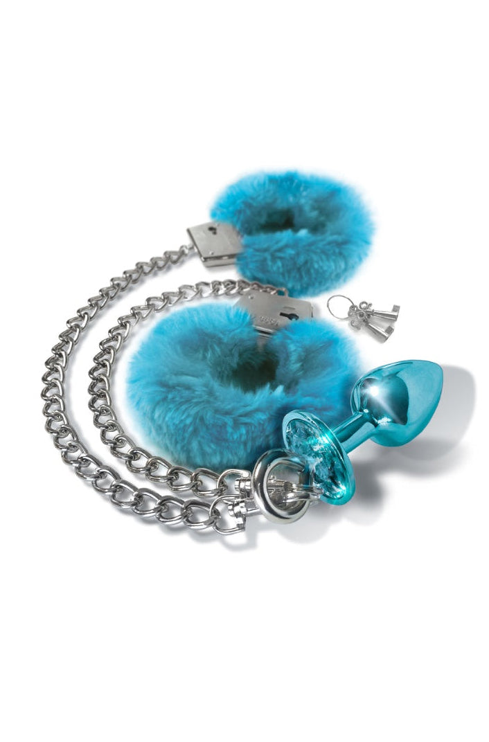 Overhead view of blue fur cuffs, silver chain, blue metallic plug and two silver keys laid flat