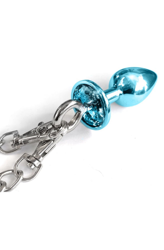 Close-up of blue metallic butt plug with teardrop shape showing connection point to silver chain