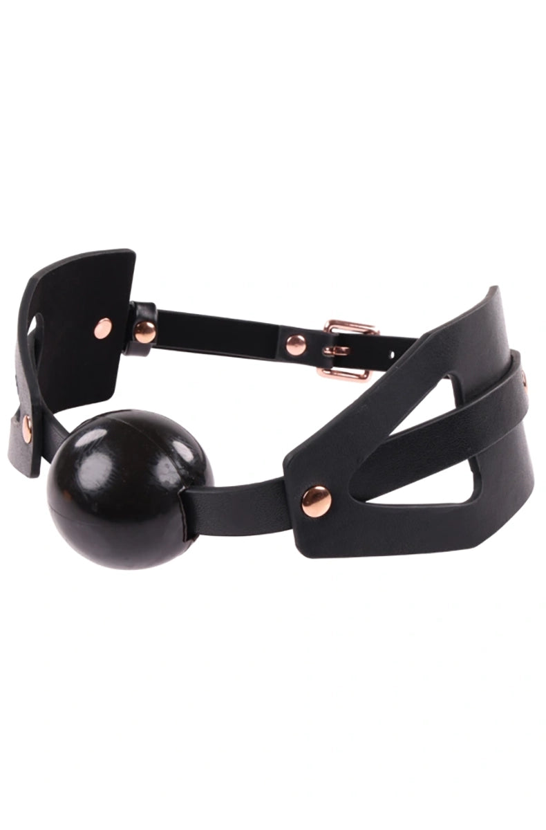 Soft black ball gag on a cutout black faux leather V-strap with rose-gold buckle, rivets, and slim center adjustment strap.