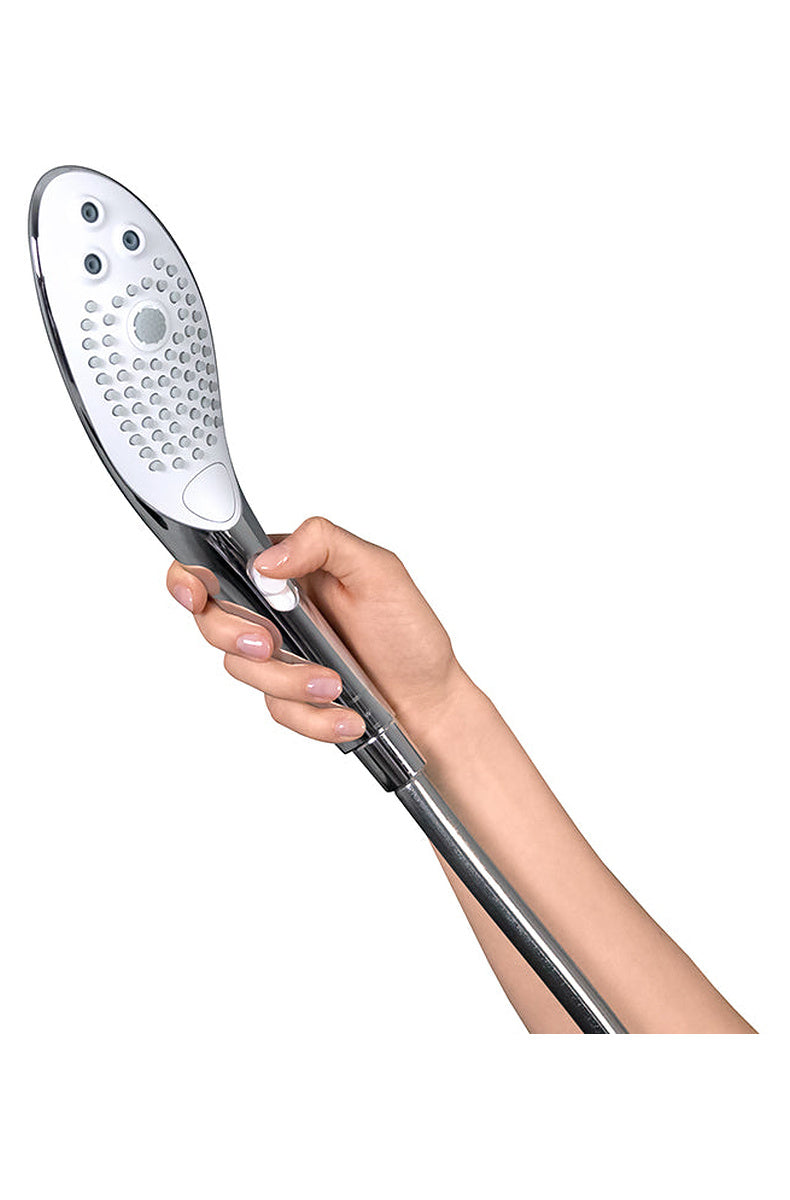 Hand holding the Womanizer Wave chrome shower head connected to a shower hose