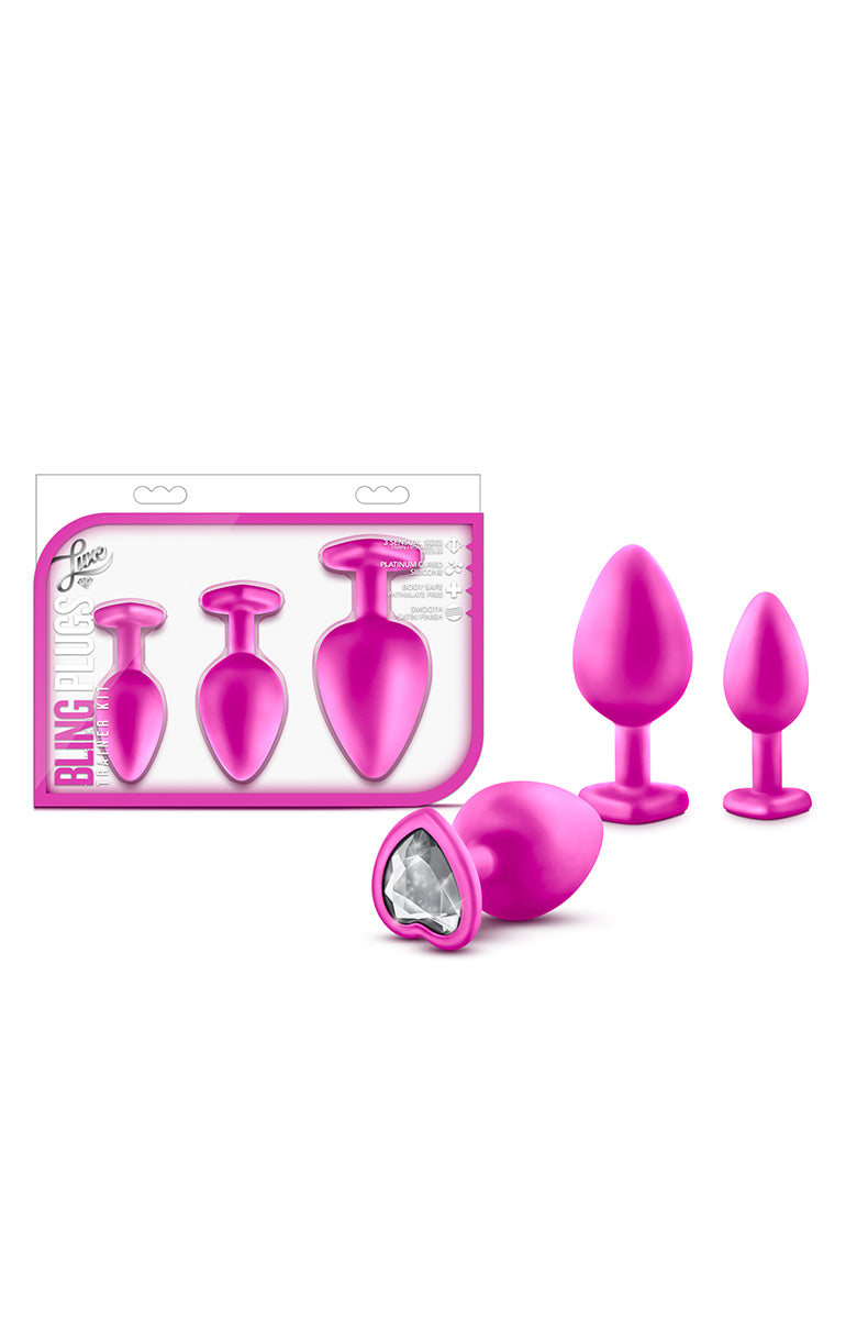 Pink anal training kit with three graduated plugs, tapered tips, narrow necks, and flared bases set with white gem accents.