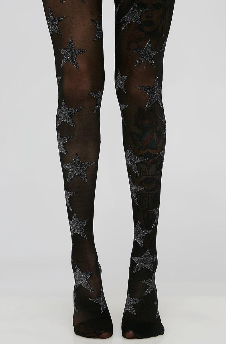 Black sheer tights printed with large silver-glitter stars scattered across both legs.