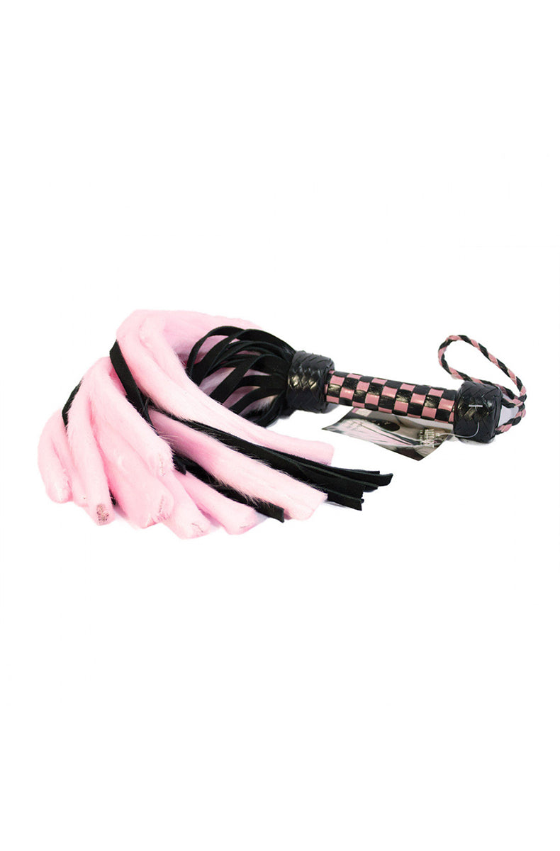Full view of the pink and black flogger hanging by its pink and black braided wrist cord with a hangtag attached.