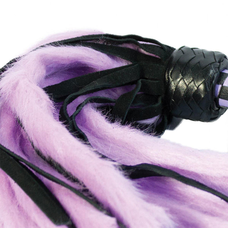 Full view of the lavender and black flogger hanging by its braided lavender and black wrist cord.