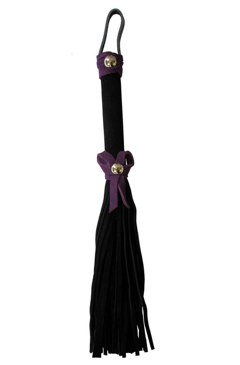 Petite black suede flogger with a black wrapped handle and a small purple suede bow knotted at the base of the falls.
