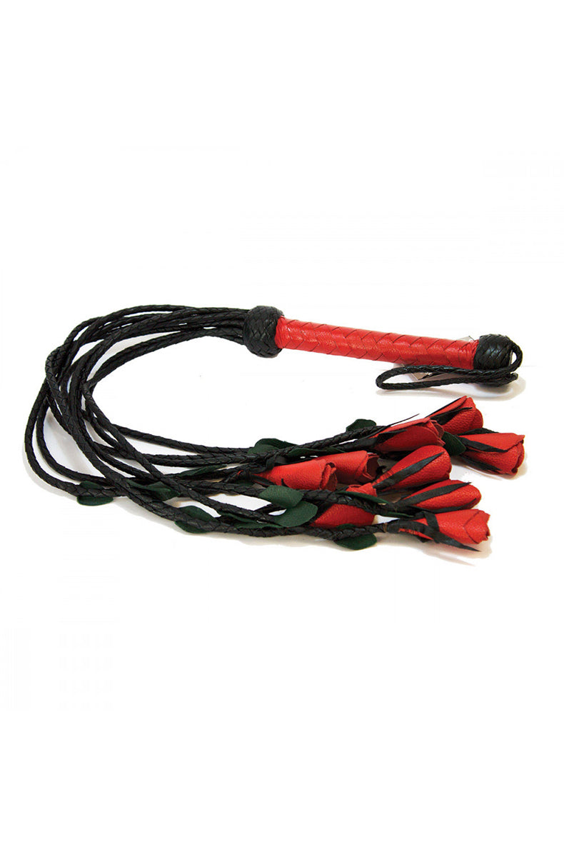 Side view of the red roses flogger laid flat with red woven handle and red leather rose tips and green leaves spread out.