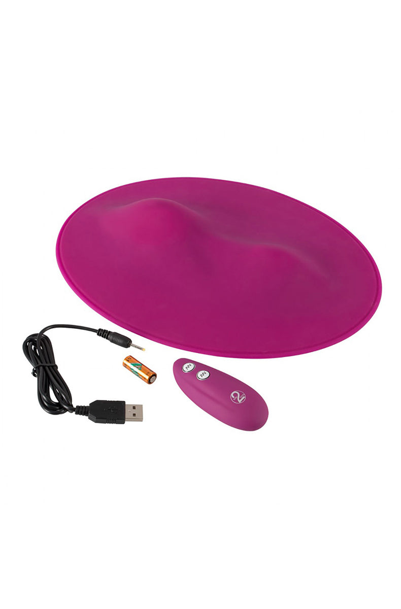 Pink Vibepad with USB cable, battery and matching pink remote control laid flat