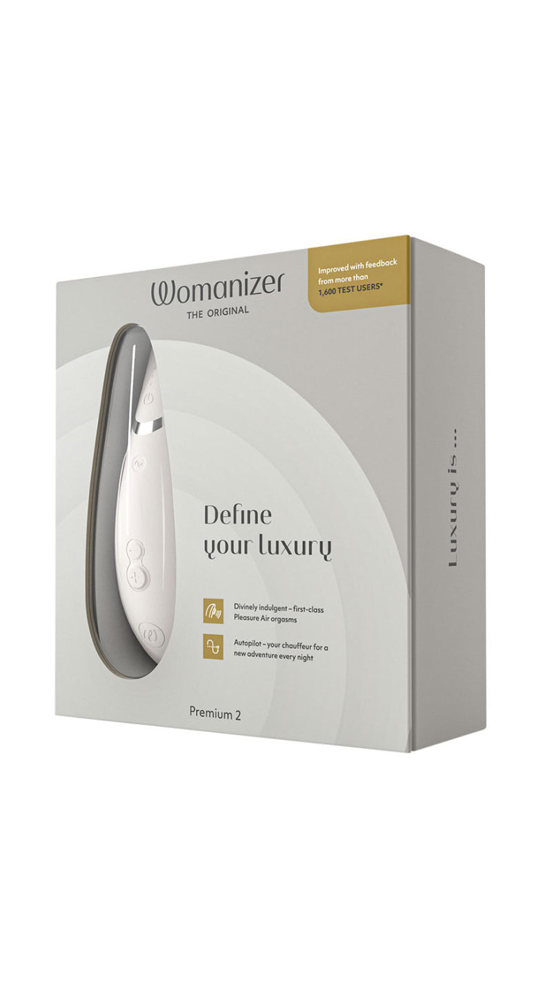 Womanizer Premium 2 in matte light gray with USB charging cable.