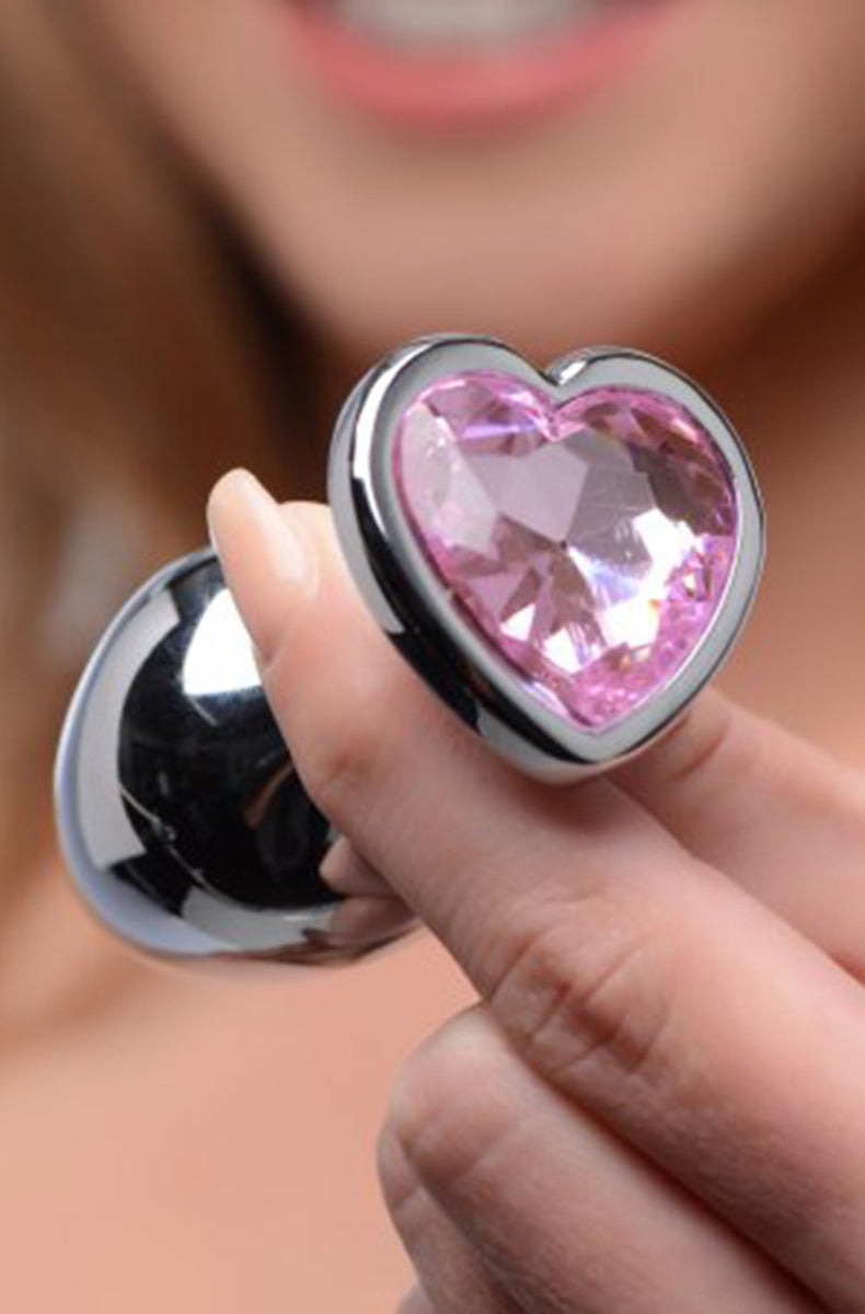 Pink heart gem aluminum plugs lined up by size from small to large.