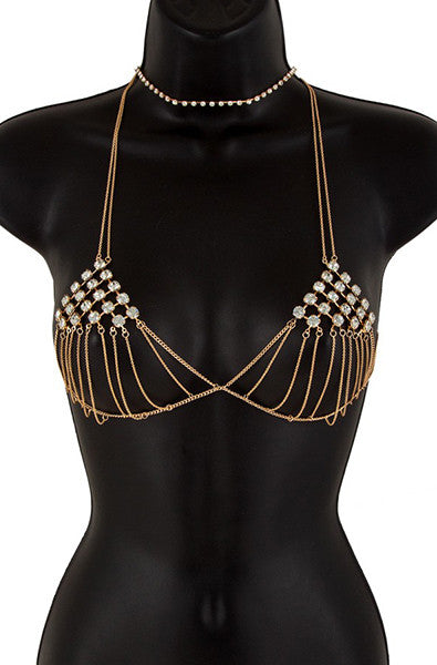 Gold-tone body chain bra with rhinestone-bezel chain triangles, paired with a delicate matching rhinestone choker on a black bust form.