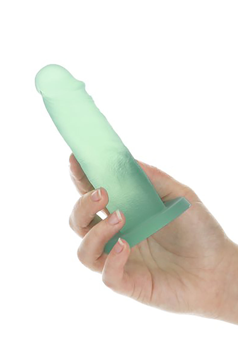 Hand holding the mint green Mint Mojito dildo by its suction cup to show scale