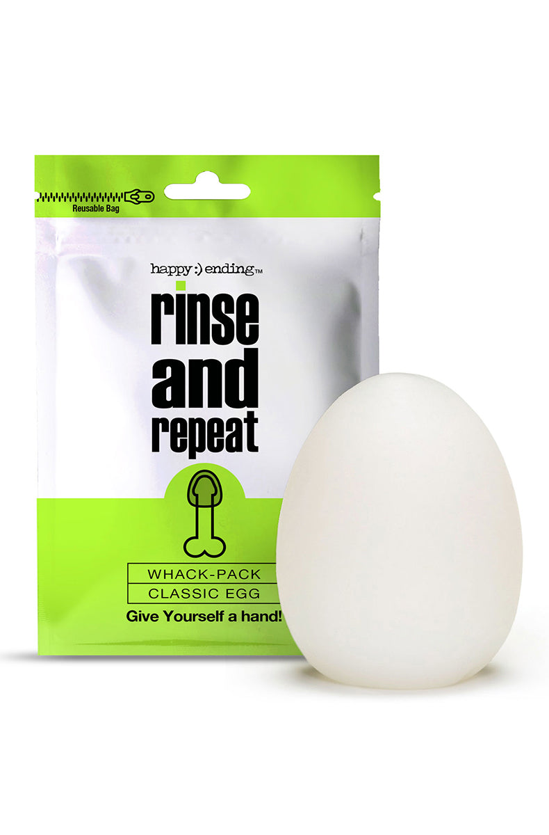 Front view of Happy Ending Whack Pack Egg, green-and-white foil pouch beside a smooth white translucent TPE egg stroker.
