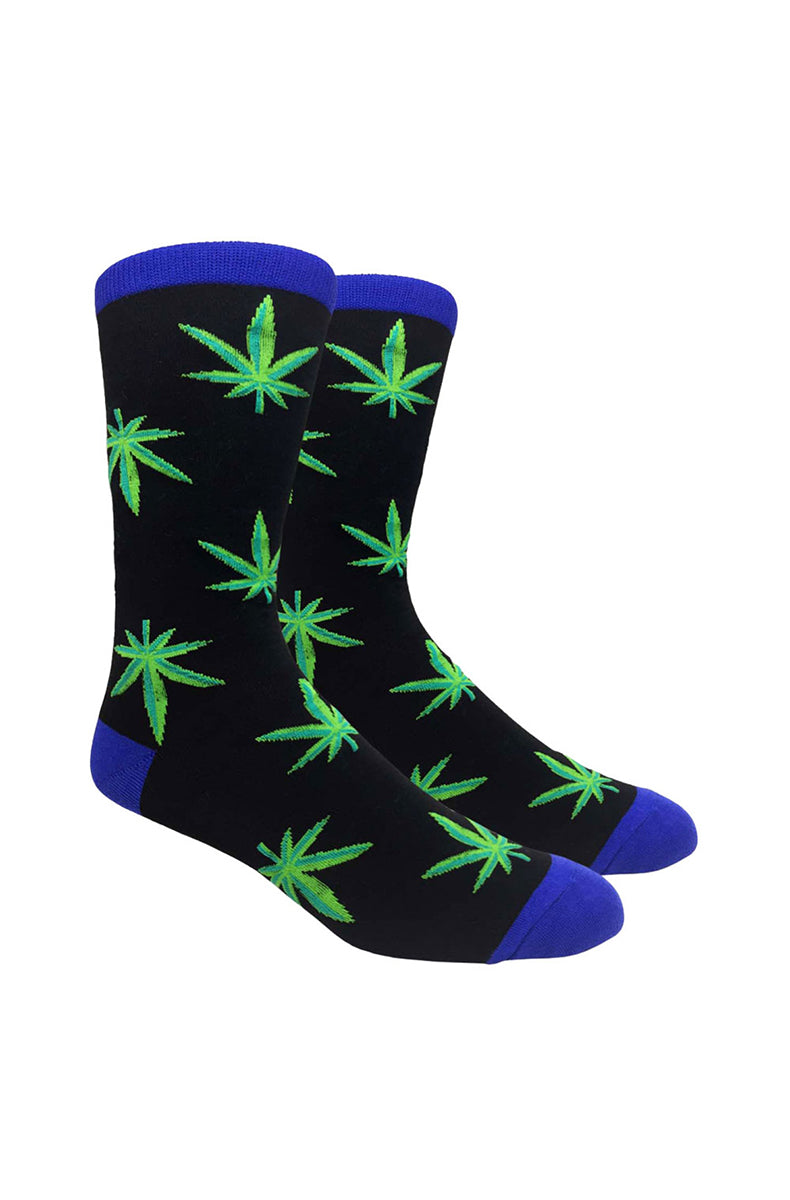 Black crew socks with bright green knit cannabis leaf graphics scattered across the body, with a blue cuff, heel, and toe.