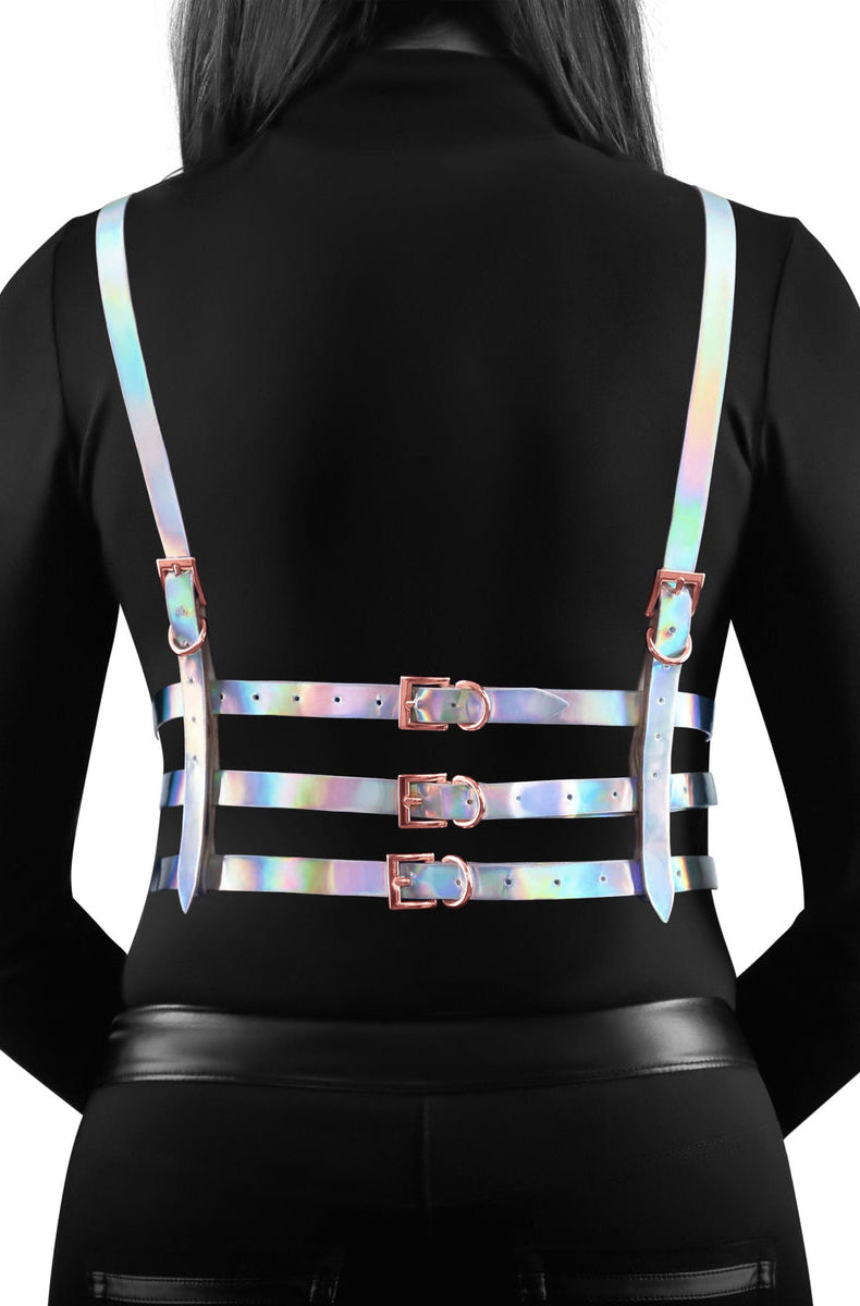 Silver-iridescent holographic vinyl chest harness with single neck loop, triangle-outline cups, horizontal underbust band, and rose-gold rivets.