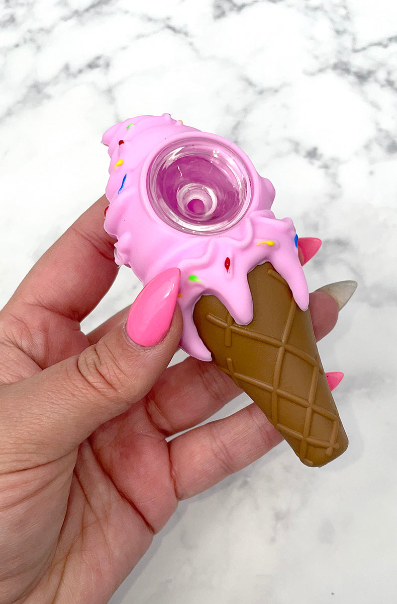 Hand holding a pink ice cream cone silicone pipe showing the removable borosilicate glass bowl set into the scoop.