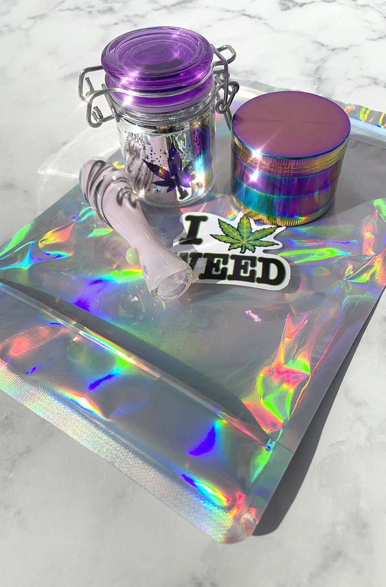 Stoner unicorn kit: purple swirl glass chillum pipe, hinged glass storage jar, 4-part rainbow grinder, smell-proof bag.