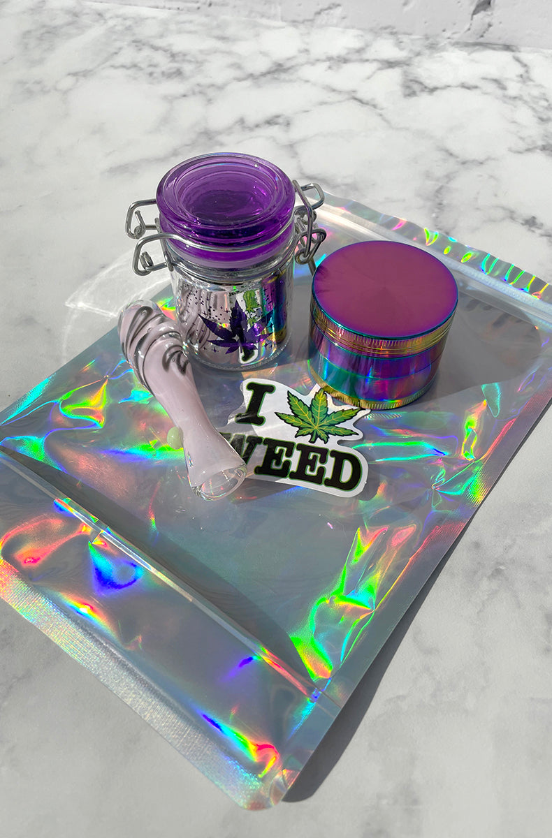 Stoner unicorn kit: purple swirl glass chillum pipe, hinged glass storage jar, 4-part rainbow grinder, smell-proof bag.