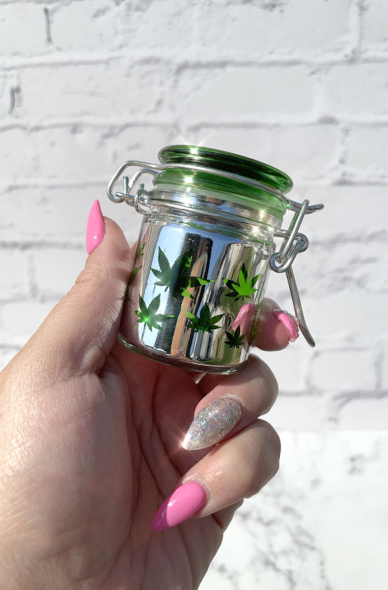 Rainbow anodized four-piece zinc-alloy grinder shown closed from above on the holographic pouch.