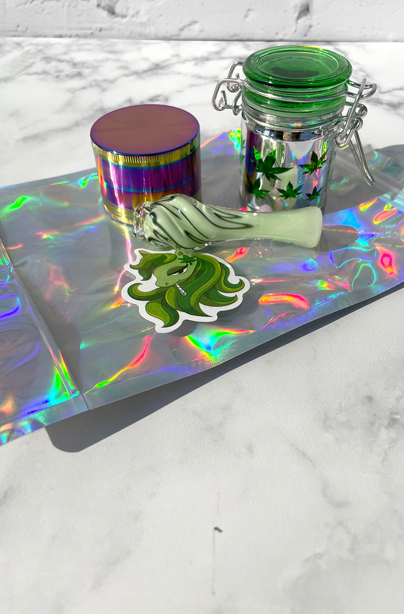 Mystery green unicorn sticker shown beside the stash kit pieces on the holographic pouch.