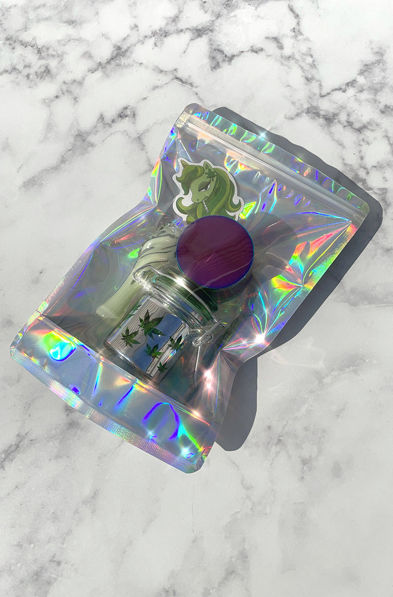 Closeup of the rainbow anodized four-piece zinc-alloy grinder and the glass swirl chillum pipe from the starter pack.