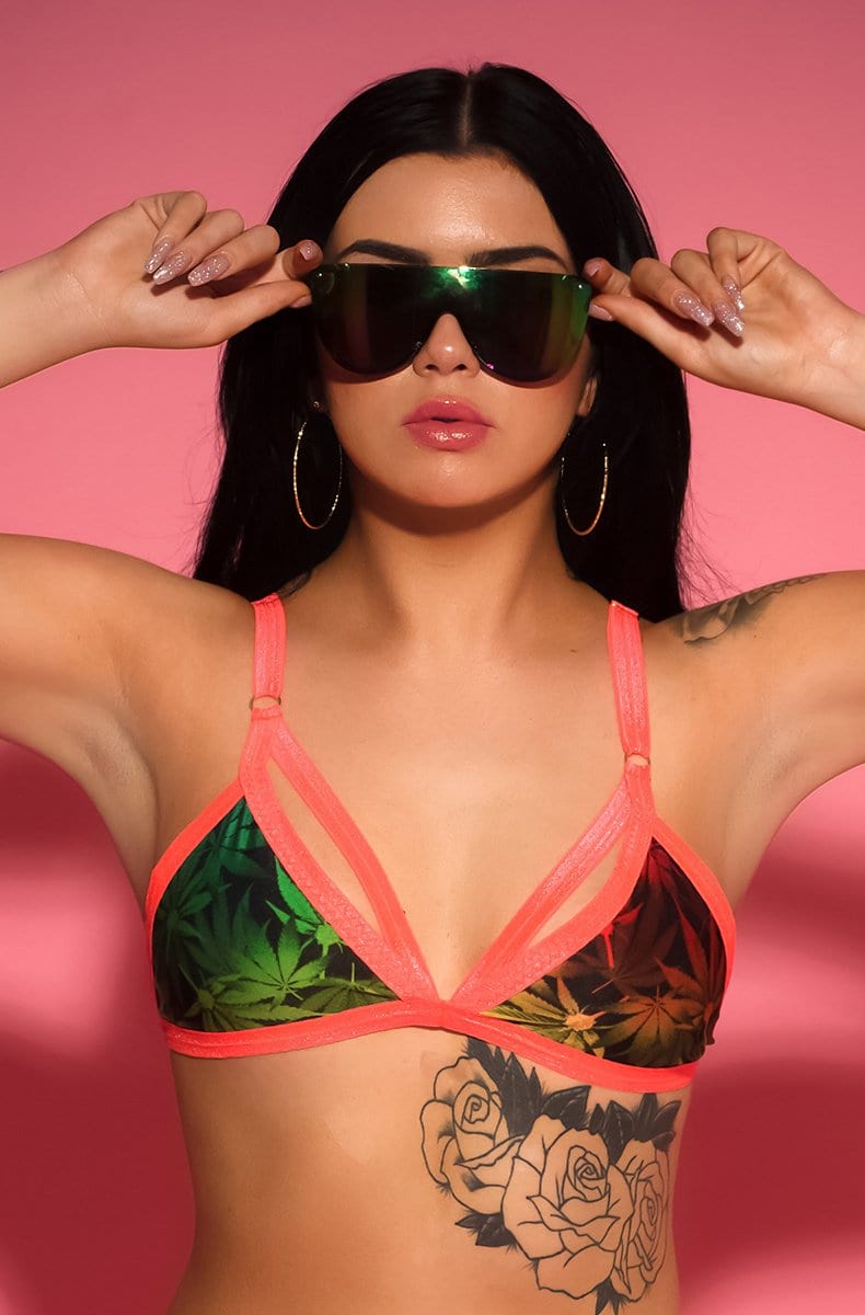 Triangle cage bralette in red yellow green cannabis-leaf print on black with neon coral elastic cage straps