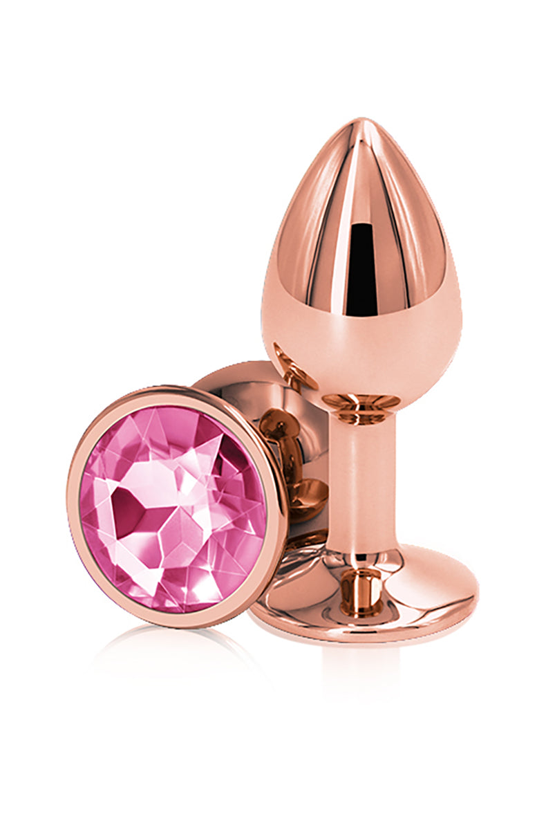 Rose gold aluminum small butt plug with a tapered shaft and a flared round base set with a faceted pink gem. NS Novelties.