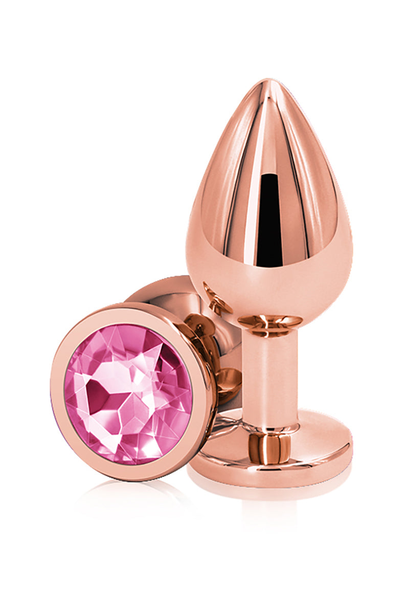 Rose gold aluminum medium butt plug with a tapered shaft and a flared round base set with a faceted pink gem. NS Novelties.