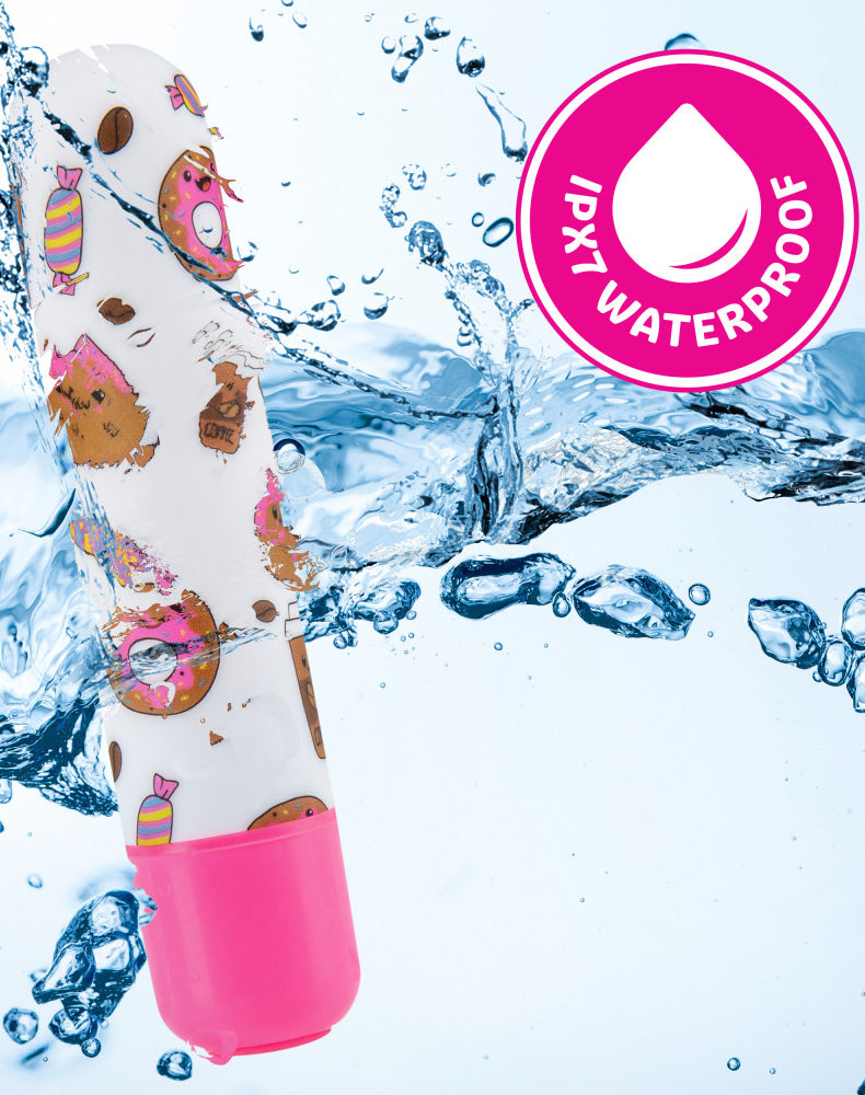 Mini Sweet Rush Bullet vibrator side view, white body with sweets print over a hot pink push-button base.