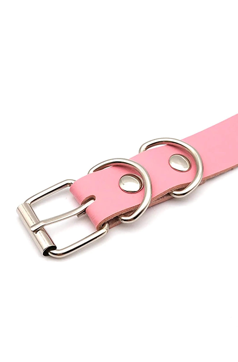 Pink, black, and red vegan leather collars with silver rhinestone-encrusted letters spelling CUSTOM as a sample, all with silver buckles.