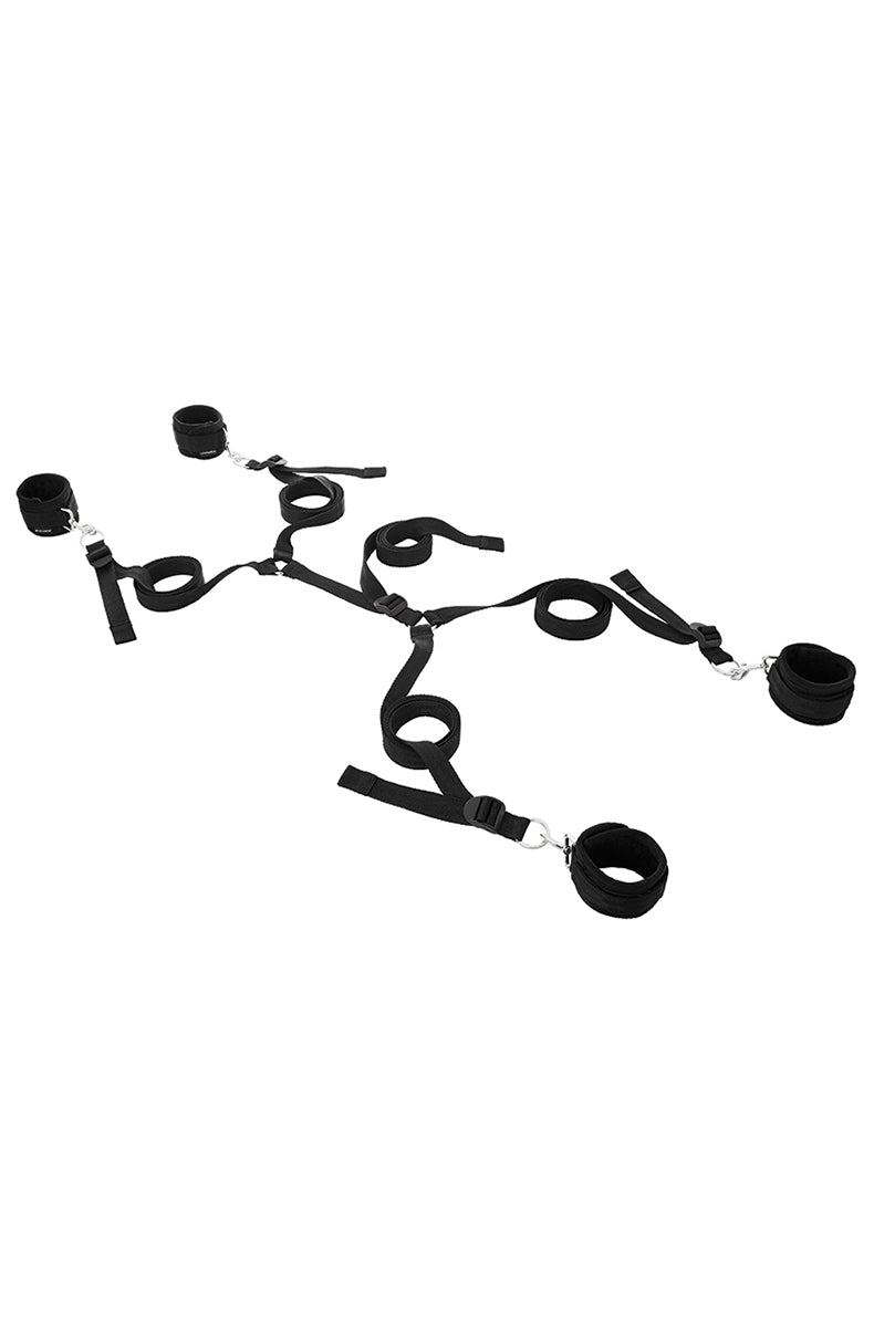 Full layout of the black nylon under-the-bed restraint system with four cuffs, adjustable straps, and clips.