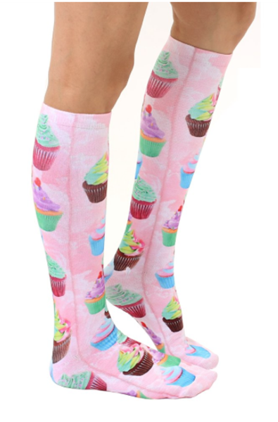 Pink knee-high socks with a photo-real print of pastel-frosted cupcakes scattered cuff to toe.