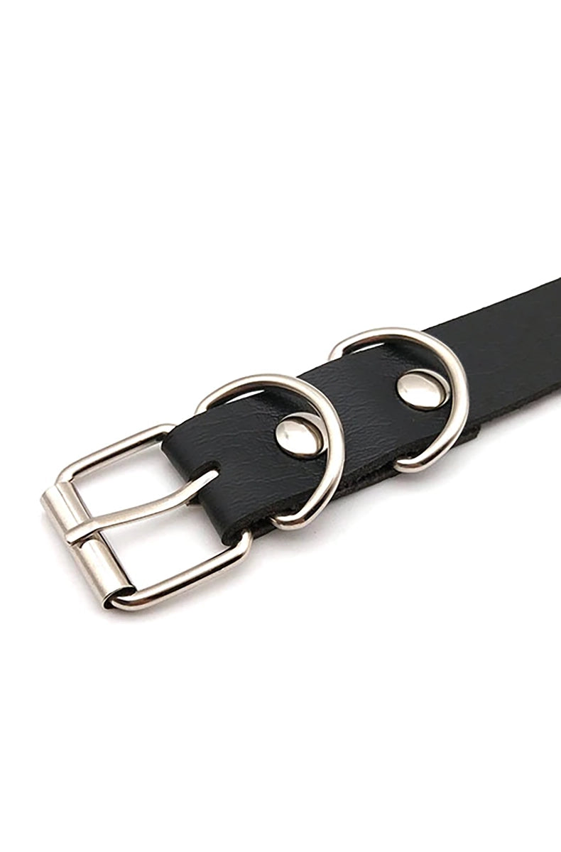 Black vegan leather collar with raised rose-gold metal letters spelling CUSTOM as a sample, with silver buckle and D-rings at the back.