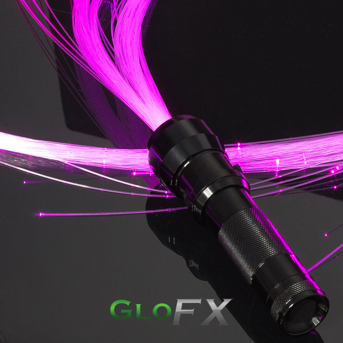 Person wearing black holding a long fiber-optic LED whip with pink and white glowing fibers trailing in the air against a purple-blue lit background.