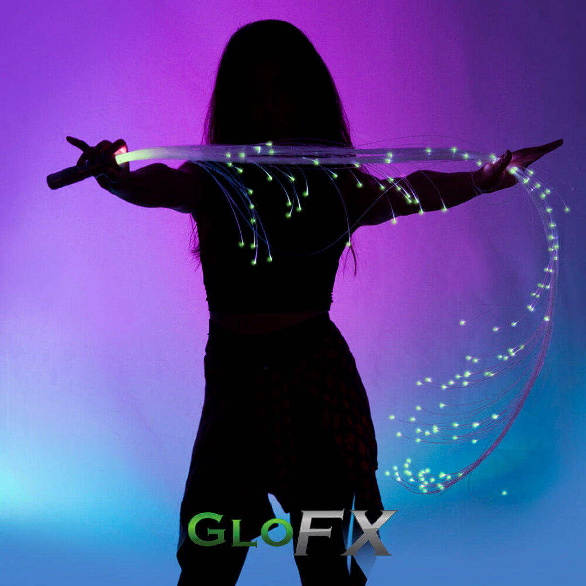 Person wearing black holding a long fiber-optic LED whip with pink and white glowing fibers trailing in the air against a purple-blue lit background.