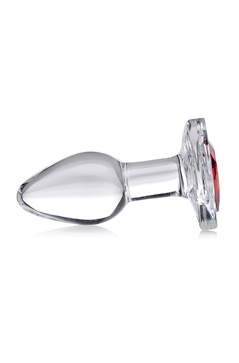Side view of small clear glass anal plug with red heart gem base showing tapered teardrop body and narrow neck.