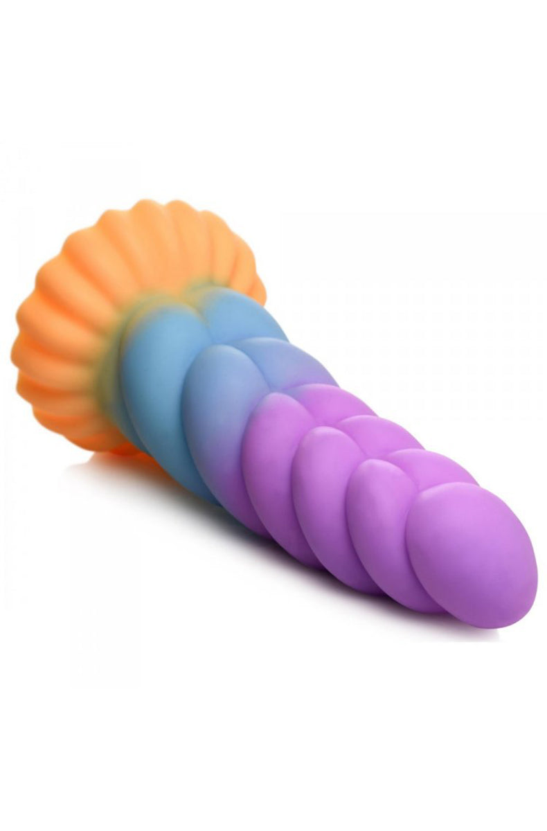 Pastel silicone unicorn dildo from the side showing twisted spiral horn shaft.
