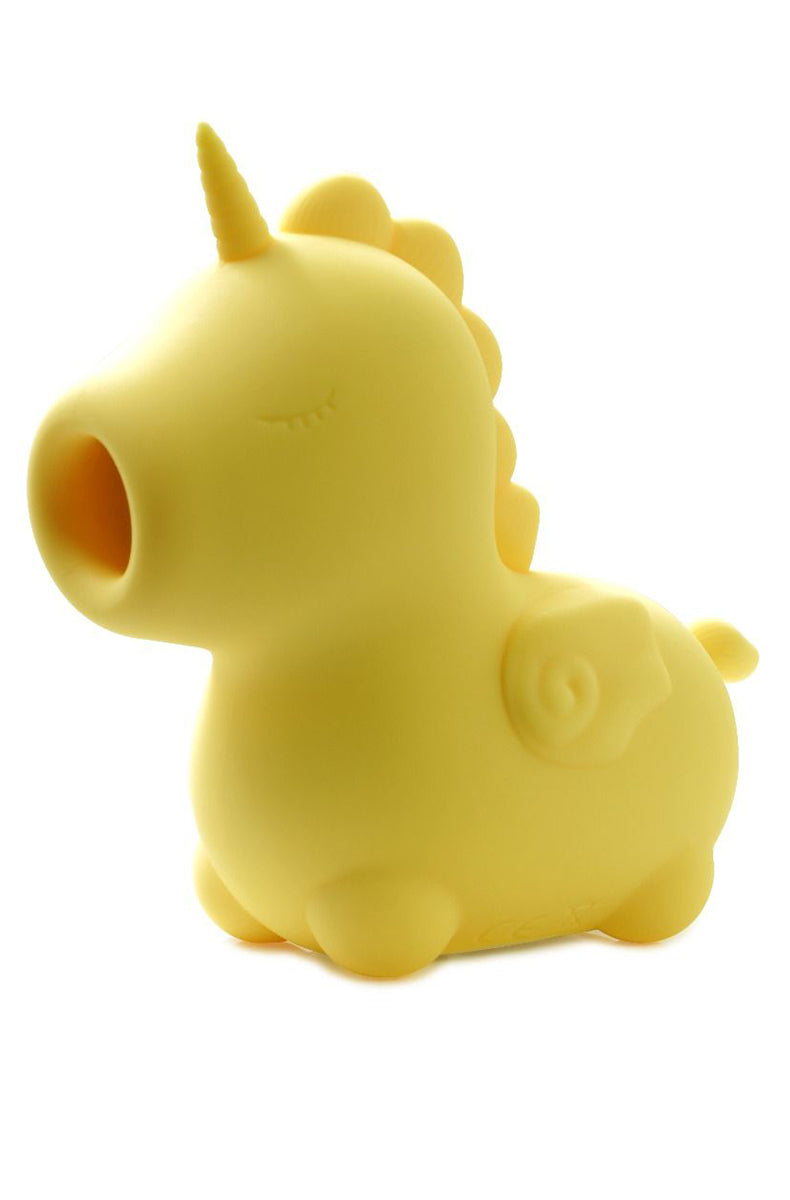 Yellow silicone Unihorn Bean Blossom unicorn vibrator standing in front of its packaging insert.