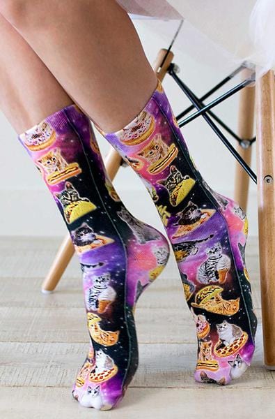 Crew socks with photo-print cats perched on pizza slices, tacos, and donuts across a purple and pink galaxy background.