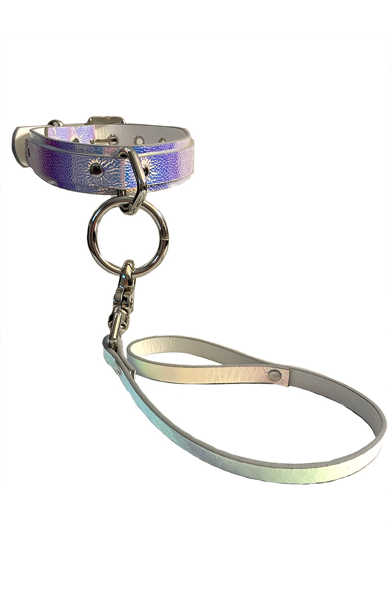 Matching holographic vegan-leather collar and leash set in iridescent purple-blue-pink, joined at the collar's silver O-ring by the leash's silver swivel snap clip.