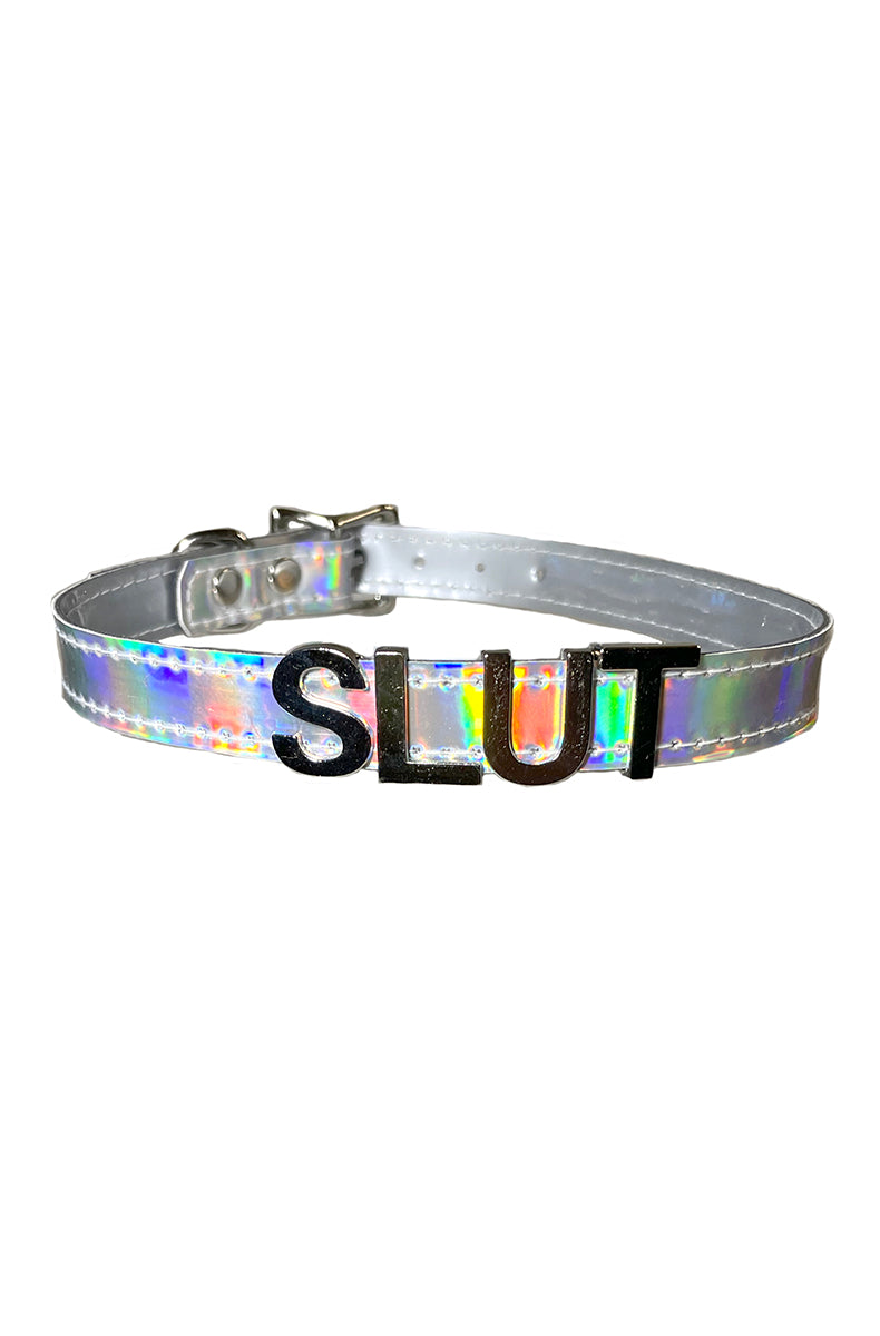 Holographic silver vegan-leather collar with "SLUT" in metallic silver chrome raised lettering across the front.