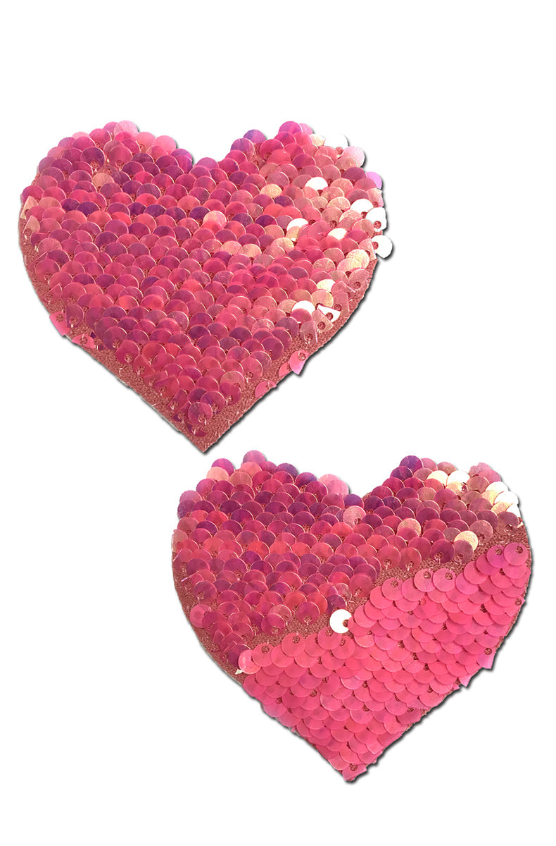 Two heart-shaped flip-sequin pasties in hot pink with iridescent peach-cream showing on the partially-flipped reverse.