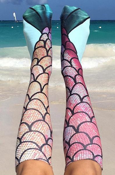 Knee-high socks with a pink and coral mermaid-scale photo print and teal-green fin tips at the cuff.