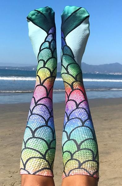 Knee-high socks with a rainbow mermaid-scale photo print and deep green fin tips at the cuff.