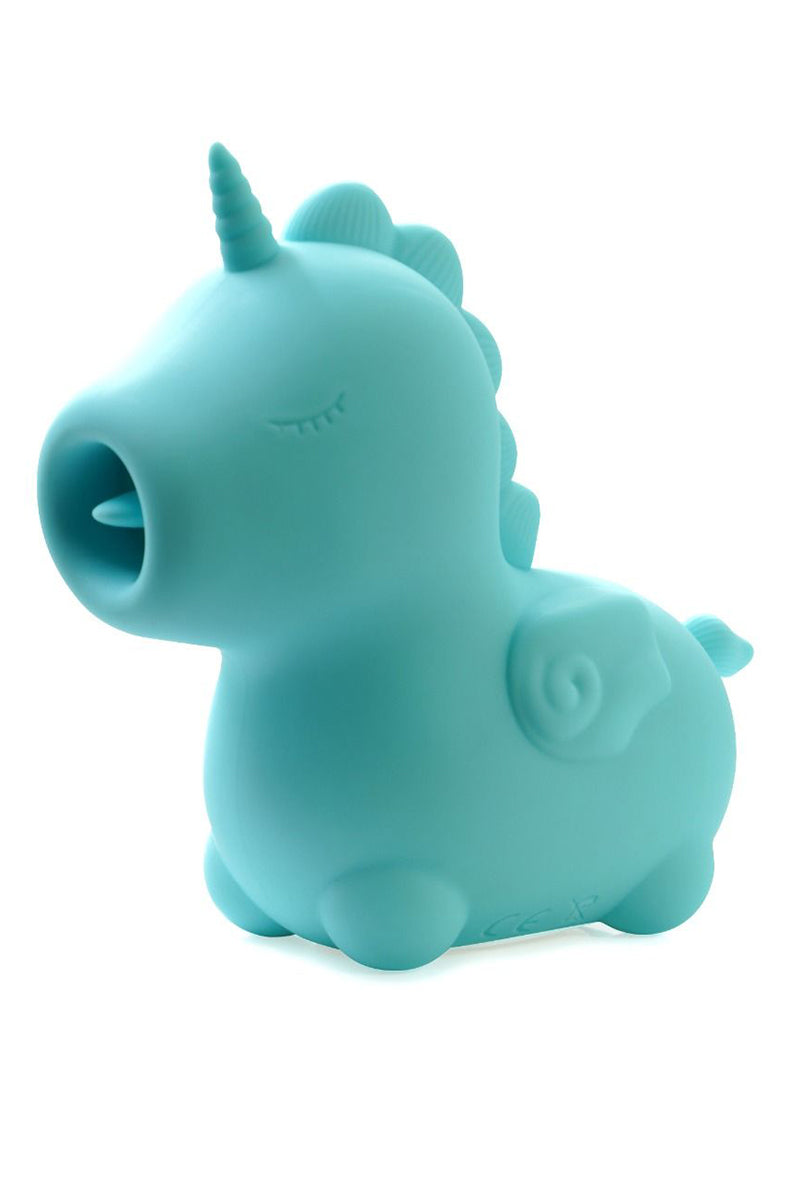 Blue silicone Unihorn Mount n Peak unicorn vibrator standing in front of a packaging insert showing the unicorn graphic.