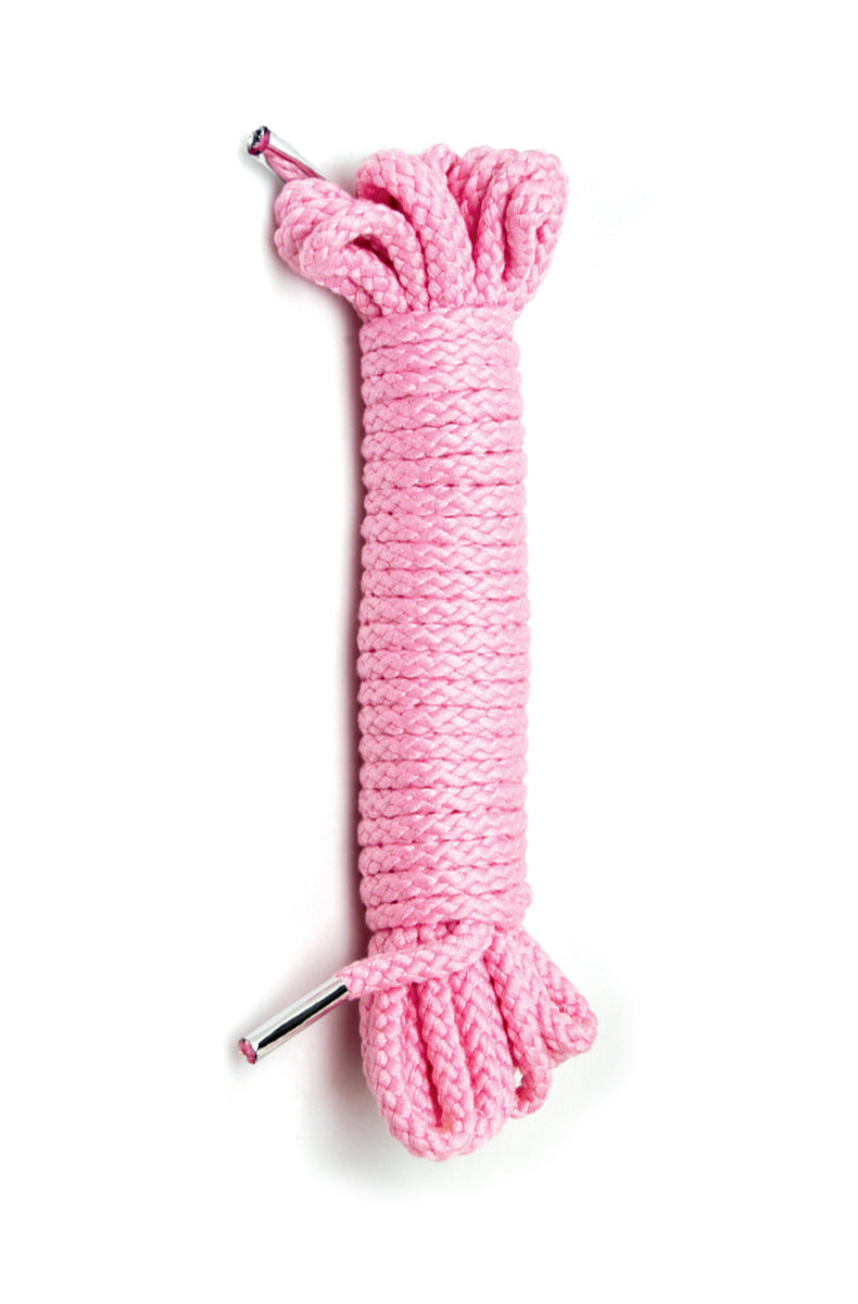Coiled bundle of soft pink braided bondage rope with two silver metal end caps and a tight cross-weave pattern.