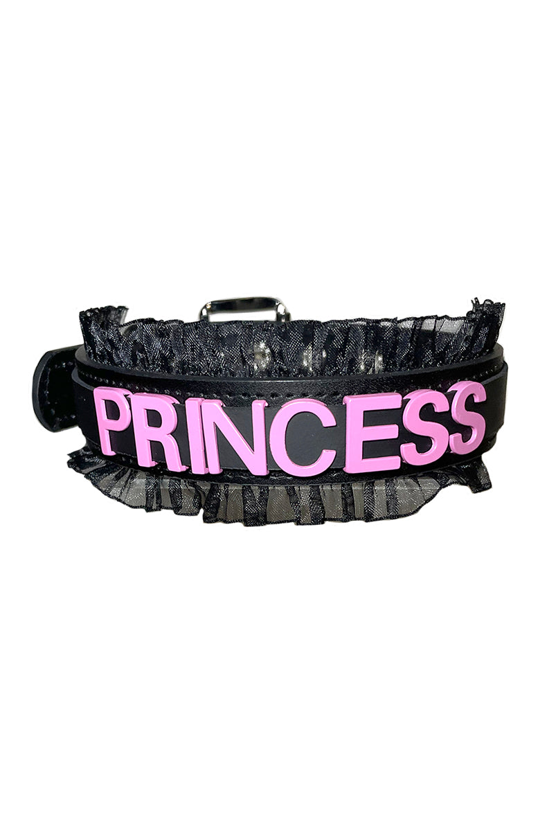 Black vegan-leather collar with "PRINCESS" in bold pink raised lettering and a black sheer organza ruffle along both edges.