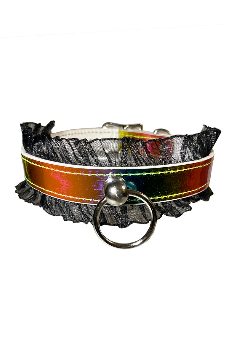 Iridescent rainbow holographic vegan-leather collar on a white base with a black sheer organza ruffle along both edges and a silver O-ring at the front center.