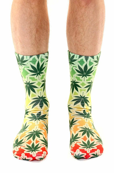 Crew socks with cannabis leaves printed over a green to yellow to red Rasta gradient from cuff to toe.